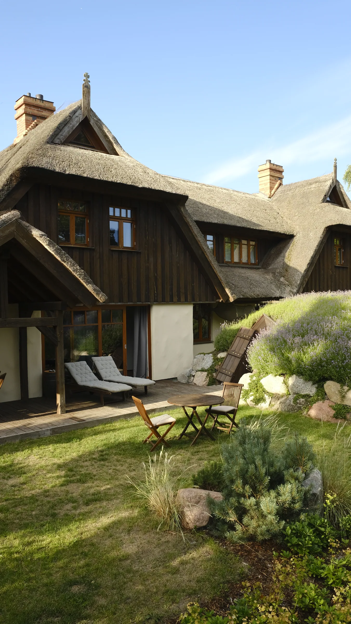 Das HaferLandHaus mit begruentem Dach und Terrasse im Sommer